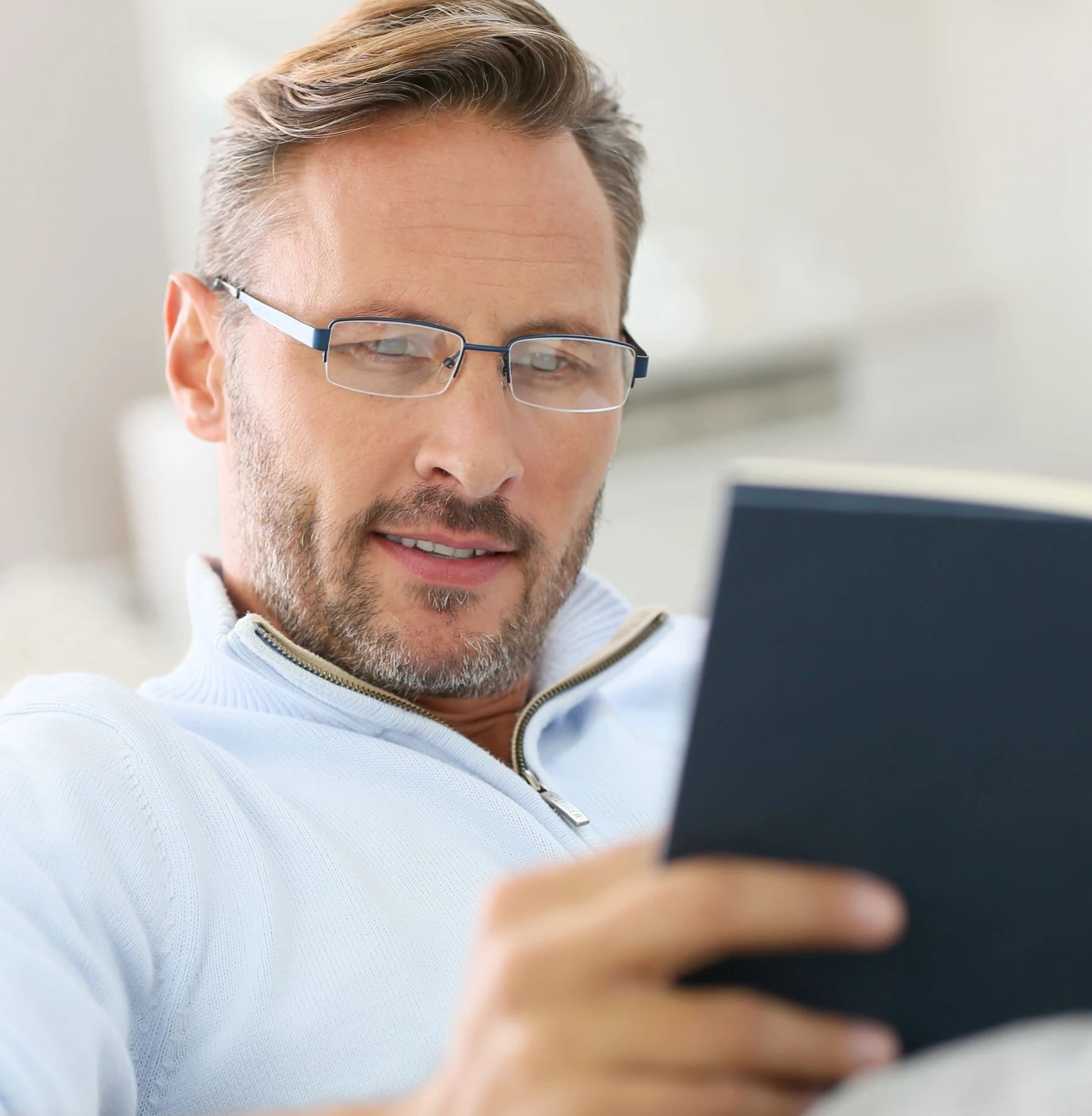 Homem com óculos de grau lendo em um tablet